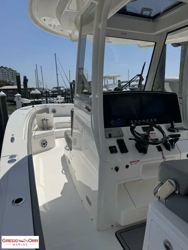 Slide: The Image of 2025 Regulator 30XO Crossover boat interior with helm, docked at marina. - 23