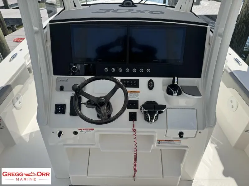Slide: The Image of 2025 Regulator 30XO Crossover boat helm with dual screens and steering wheel. - 24