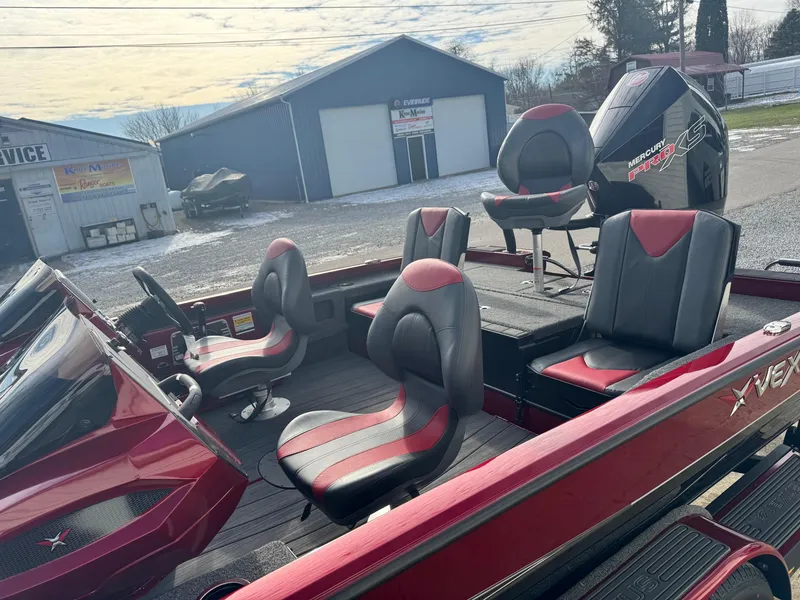 Slide: The Image of 2025 Vexus AVX1985S boat with red and black seating, parked near a service building. - 10