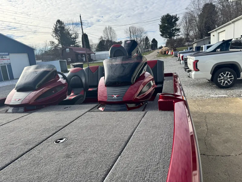 Slide: The Image of 2025 Vexus AVX1985S boat with red accents, parked outdoors near vehicles and buildings. - 9