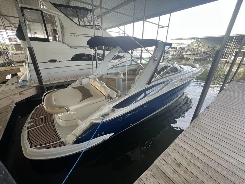 Slide: The Image of 2013 Crownline 325SS boat docked in marina, featuring sleek design and spacious seating. - 5