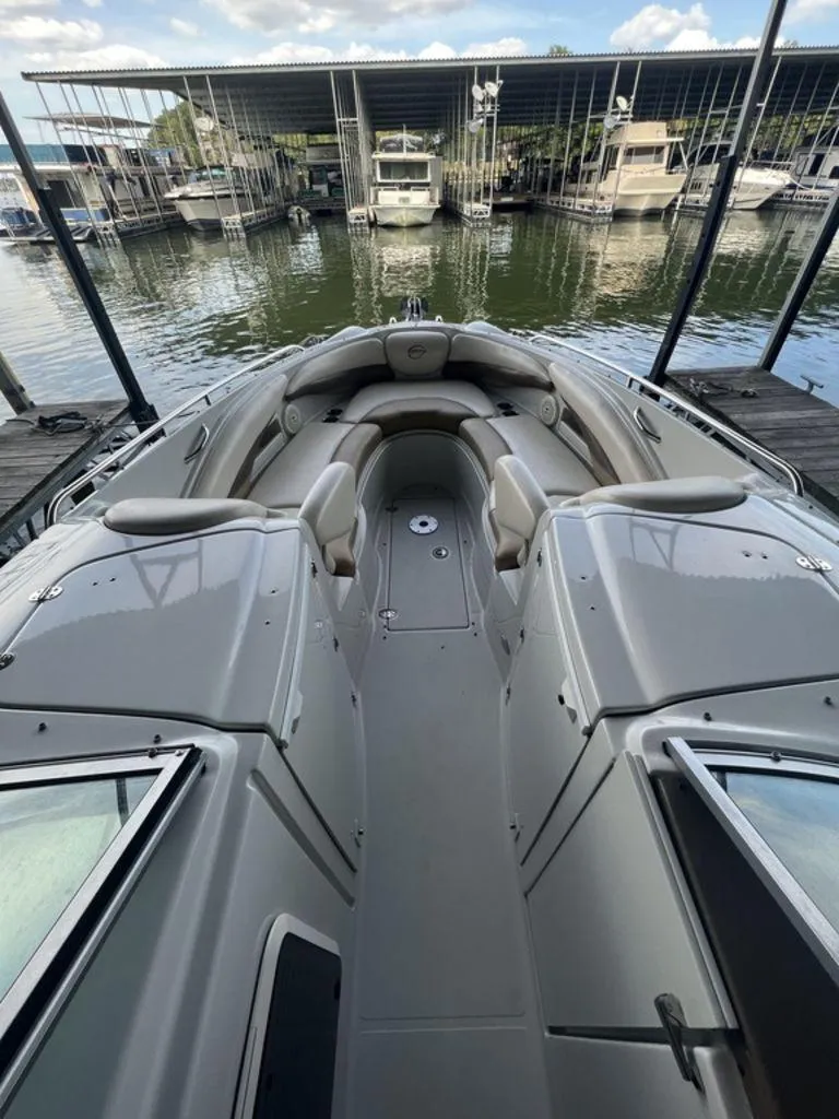 Slide: The Image of 2013 Crownline 325SS boat docked at marina, featuring spacious seating and sleek design. - 9