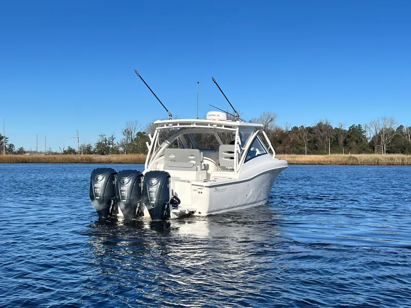 Slide: The Image of 2023 Albemarle 31 Dual Console boat on calm water with triple outboard engines. - 10