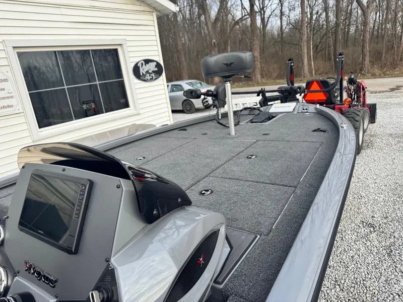 Slide: The Image of 2025 Vexus AVX1980 boat with advanced dashboard and spacious deck, parked near a building. - 6