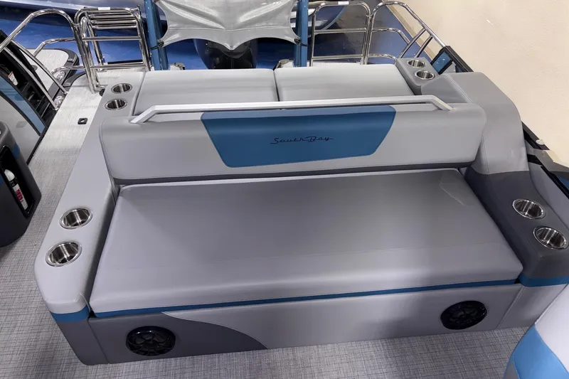 Slide: The Image of 2025 South Bay 500 boat interior with gray and blue seating, cup holders, and speakers. - 3