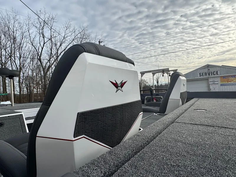 Slide: The Image of 2025 Vexus VXS21 boat seats with logo, under a cloudy sky near a service building. - 11