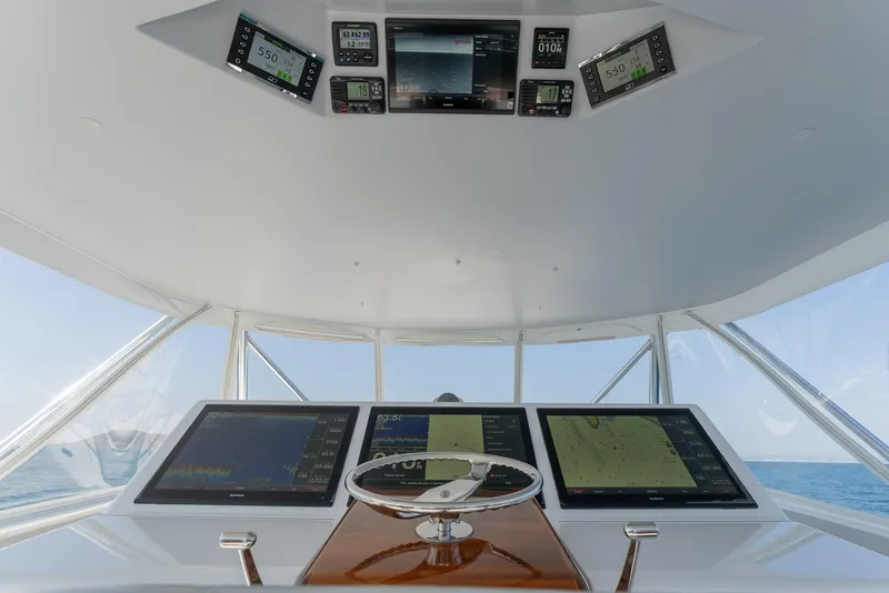 Slide: The Image of 2018 Hatteras GT70 yacht helm with advanced navigation displays and steering wheel. - 10
