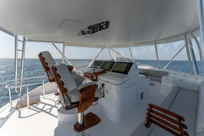 Slide: The Image of 2018 Hatteras GT70 yacht helm with ocean view, featuring modern navigation equipment and seating. - 12