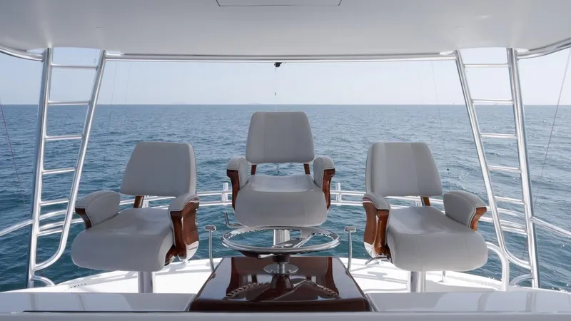 Slide: The Image of 2018 Hatteras GT70 yacht helm with three white captain chairs overlooking the ocean. - 8
