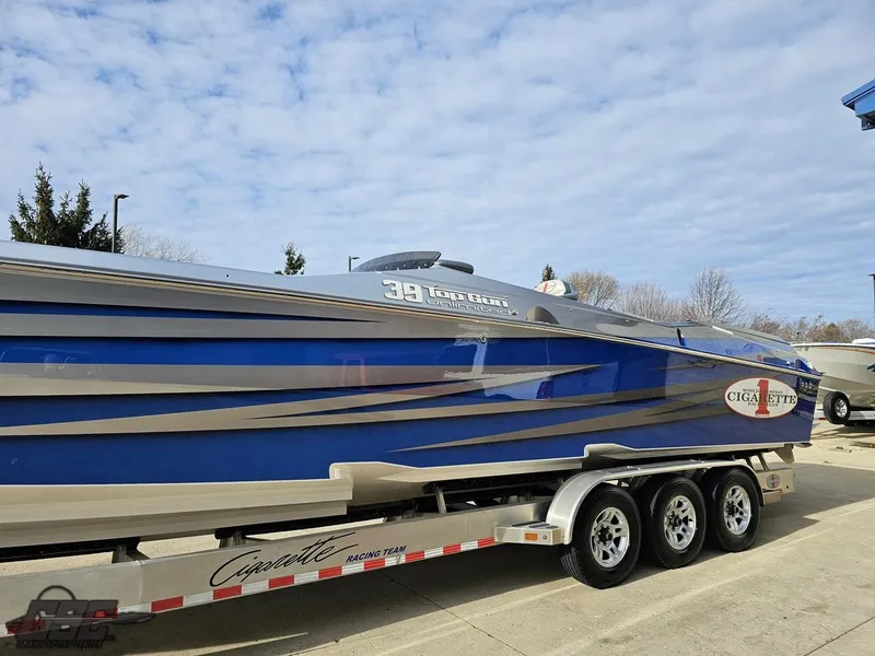 Slide: The Image of 2012 Cigarette 39' Top Gun Unlimited boat on trailer, blue and silver design. - 18