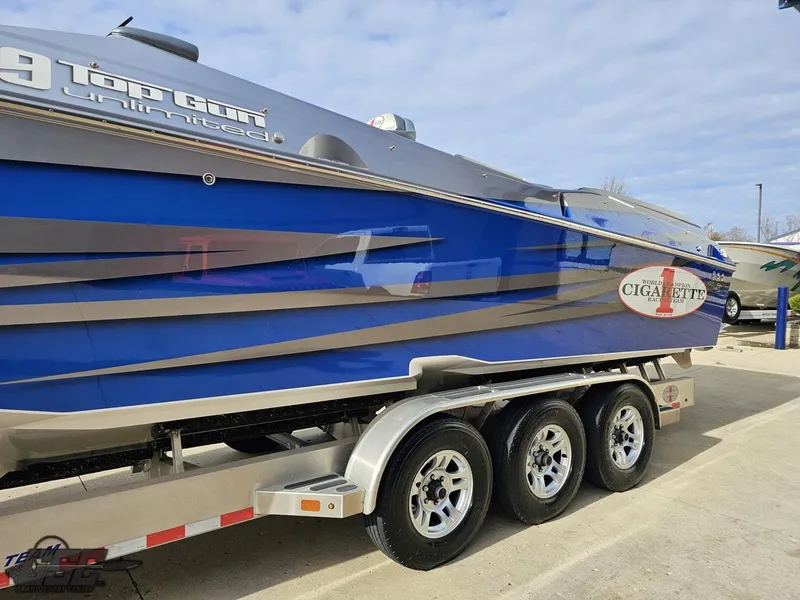 Slide: The Image of 2012 Cigarette 39' Top Gun Unlimited boat on trailer, blue and silver design. - 22