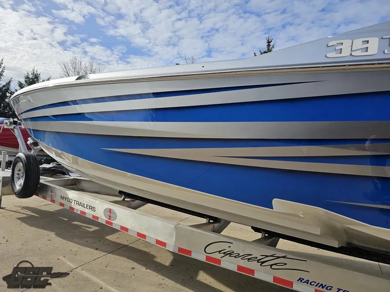 Slide: The Image of 2012 Cigarette 39' Top Gun Unlimited boat on trailer, blue and silver design. - 23