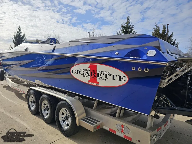 Slide: The Image of 2012 Cigarette 39' Top Gun Unlimited boat on trailer, blue with racing decals. - 27