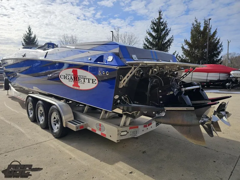 Slide: The Image of 2012 Cigarette 39' Top Gun Unlimited boat on trailer, blue exterior, parked outdoors. - 28