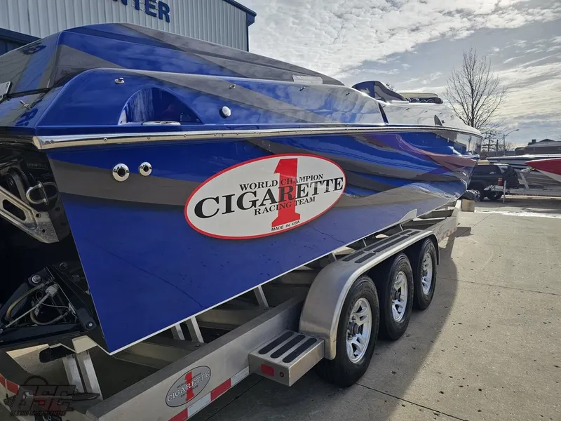 Slide: The Image of 2012 Cigarette 39' Top Gun Unlimited boat on trailer, blue with racing team logo. - 31