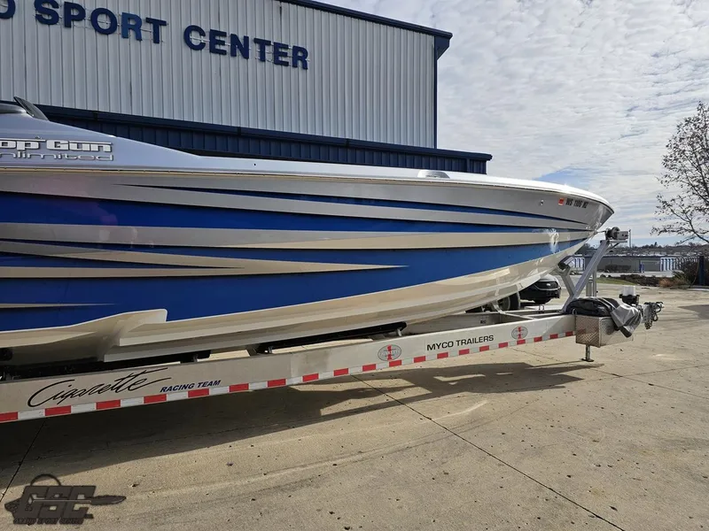 Slide: The Image of 2012 Cigarette 39' Top Gun Unlimited boat on trailer outside sport center. - 5