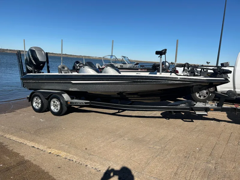 Slide: The Image of 2009 Champion 210 Elite boat on trailer, parked on roadside, with outboard motor. - 10