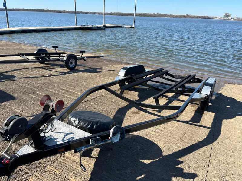 Slide: The Image of 2009 Champion 210 Elite boat on trailer, parked outdoors. - 2