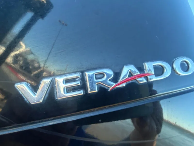 Slide: The Image of 2009 Champion 210 Elite boat on trailer, parked outdoors under clear blue sky. - 22