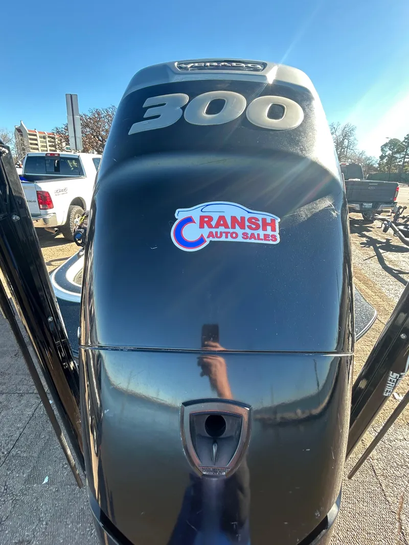 Slide: The Image of 2009 Champion 210 Elite boat trailer in parking lot, red truck in background. - 23