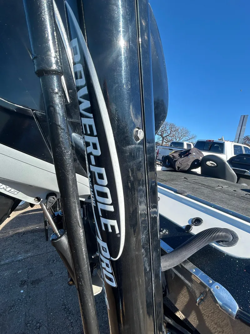 Slide: The Image of 2009 Champion 210 Elite boat interior with steering wheel and seating under sunny sky. - 24