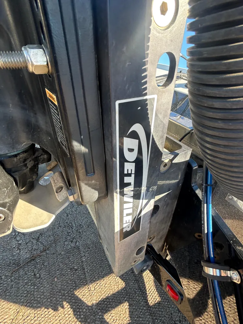 Slide: The Image of 2009 Champion 210 Elite boat with spacious deck in a sunny parking lot. - 26