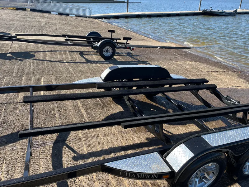 Slide: The Image of 2009 Champion 210 Elite boat on trailer by the water, featuring Minn Kota equipment. - 4