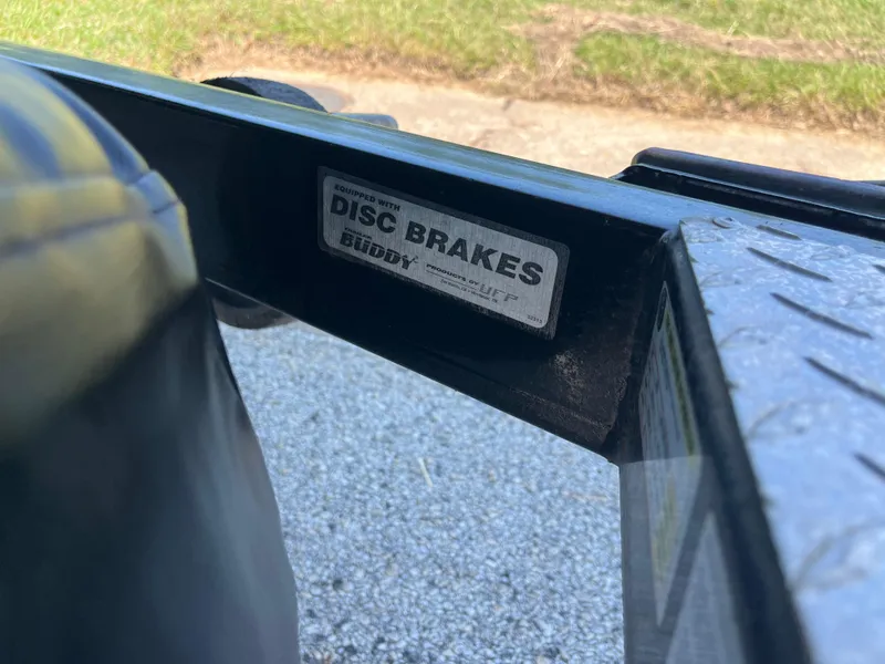 Slide: The Image of 2009 Champion 210 Elite boat trailer in parking lot, surrounded by trucks. - 45