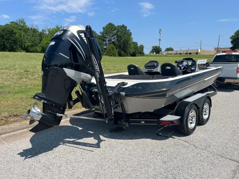 Slide: The Image of Champion 210 Elite 2009 boat trailer hitch with Fulton winch on textured ground. - 48