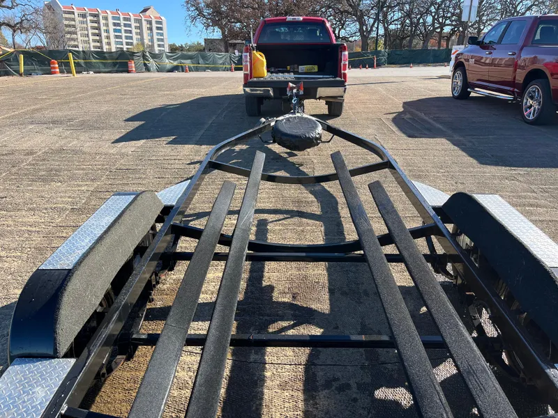 Slide: The Image of 2009 Champion 210 Elite boat on trailer by the water. - 5