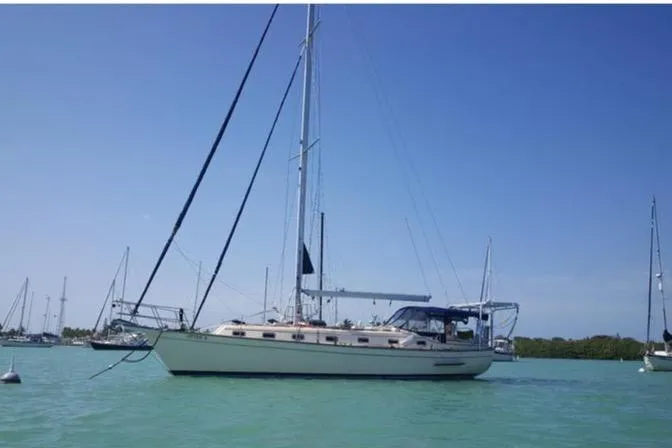 The Image of Island Packet 45 sailboat from 1999 anchored in calm waters under clear blue sky. - 0