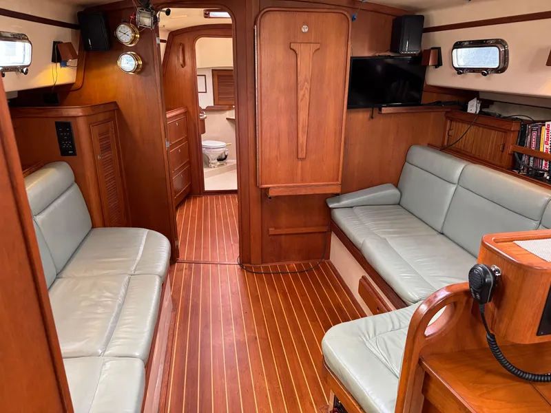 Slide: The Image of Interior of 1999 Island Packet 45 sailboat with wood finish and seating area. - 18