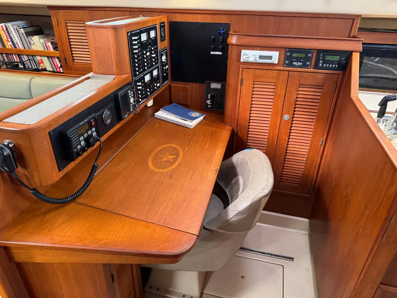 Slide: The Image of Navigation station of 1999 Island Packet 45 yacht with control panels and wooden desk. - 19