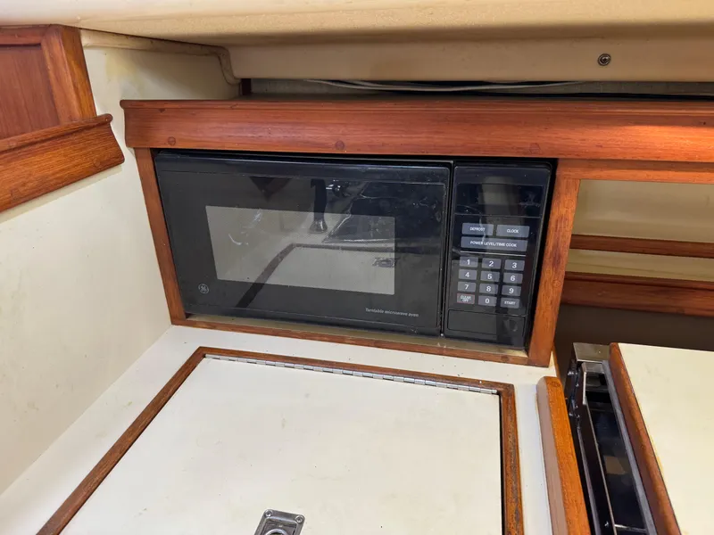 Slide: The Image of Microwave in 1999 Island Packet 45 yacht kitchen, featuring wood trim and compact design. - 25