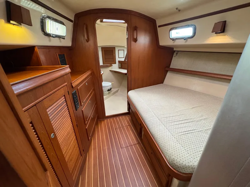 Slide: The Image of 1999 Island Packet 45 interior cabin with wooden finish and cozy bed. - 35