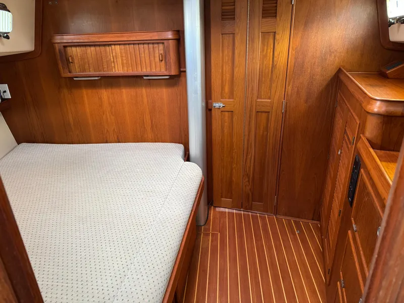 Slide: The Image of Cozy cabin interior of 1999 Island Packet 45 sailboat with wooden furnishings and bed. - 36