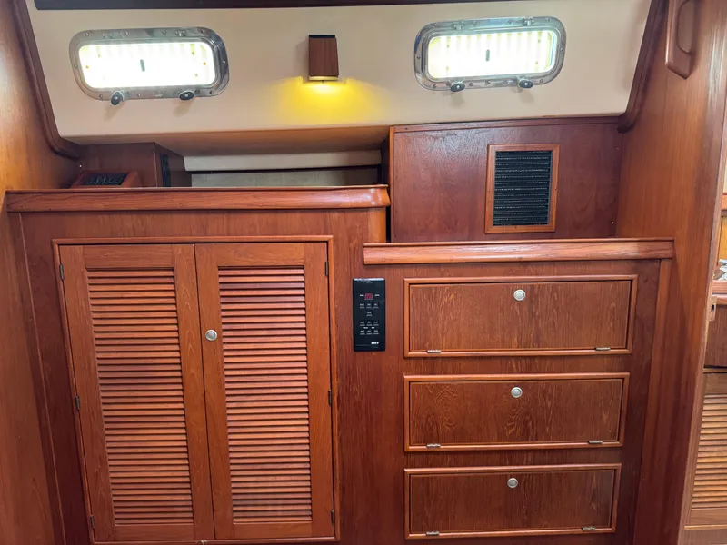 Slide: The Image of Interior of 1999 Island Packet 45 sailboat with wooden cabinets and drawers. - 37