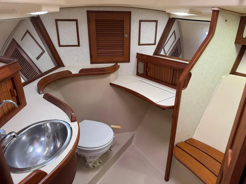 Slide: The Image of 1999 Island Packet 45 yacht bathroom with wooden accents and stainless steel sink. - 38