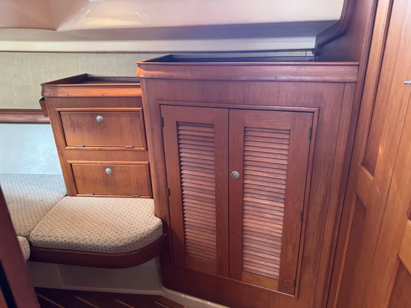 Slide: The Image of Interior of 1999 Island Packet 45 sailboat with wooden cabinetry and cushioned seating. - 42