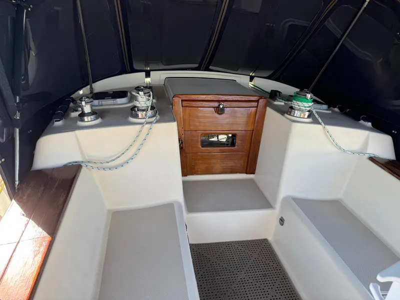 Slide: The Image of 1999 Island Packet 45 sailboat cockpit with winches, seating, and wooden storage compartment. - 6