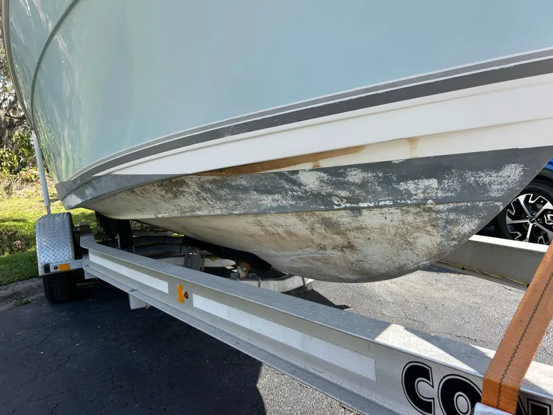 Slide: The Image of 2004 Cobia 250 Walk-Around boat on trailer, showing hull condition. - 13