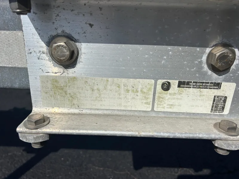 Slide: The Image of Close-up of a metal plate with bolts on a 2004 Cobia 250 Walk-Around boat. - 14