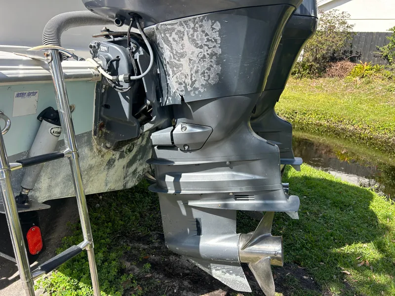 Slide: The Image of 2004 Cobia 250 Walk-Around boat engine and propeller on grassy area. - 17