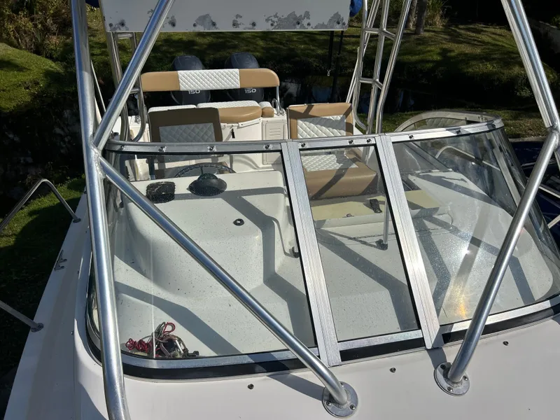 Slide: The Image of 2004 Cobia 250 Walk-Around boat with open deck and seating area. - 21