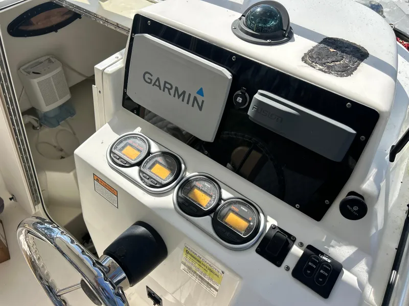 Slide: The Image of 2004 Cobia 250 Walk-Around boat dashboard with Garmin navigation system and controls. - 22