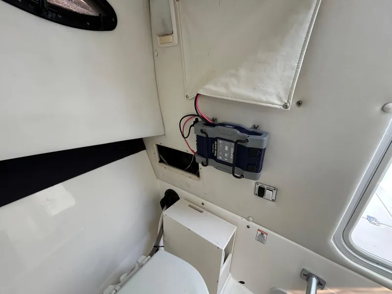 Slide: The Image of 2004 Cobia 250 Walk-Around cabin interior with mounted electronic device. - 24