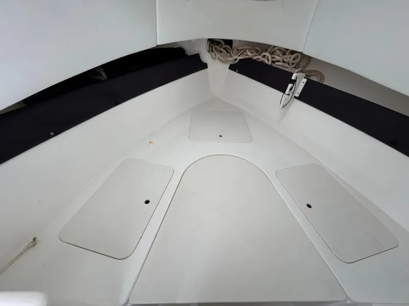 Slide: The Image of 2004 Cobia 250 Walk-Around boat interior with storage compartments and rope. - 26