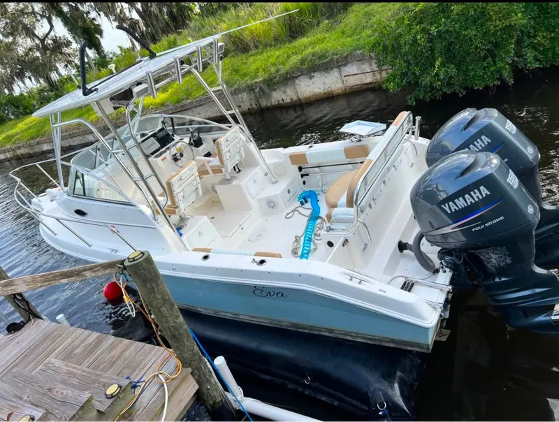 Slide: The Image of 2004 Cobia 250 Walk-Around boat with Yamaha engines docked by a canal. - 3