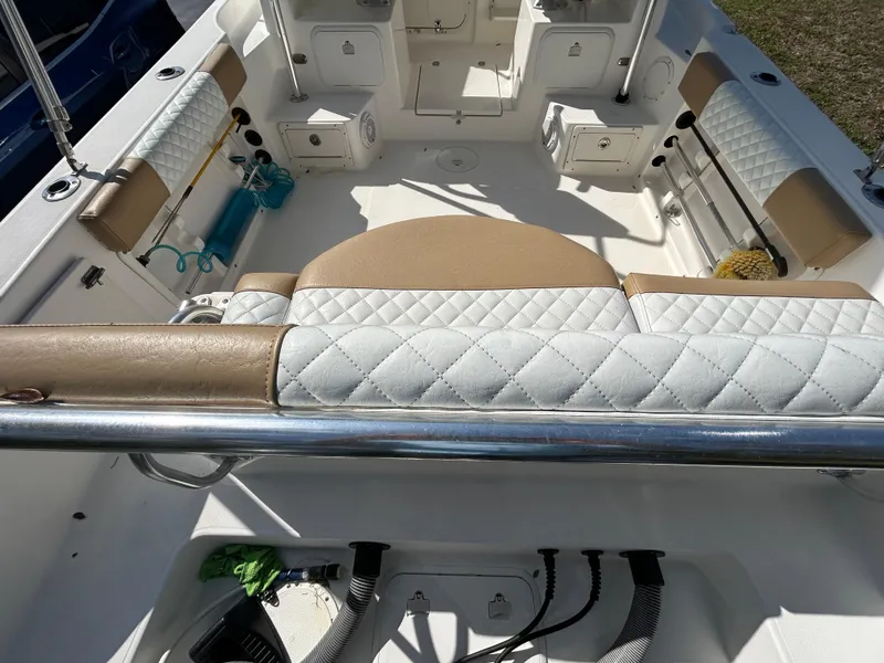 Slide: The Image of 2004 Cobia 250 Walk-Around boat interior with cushioned seating and storage compartments. - 32