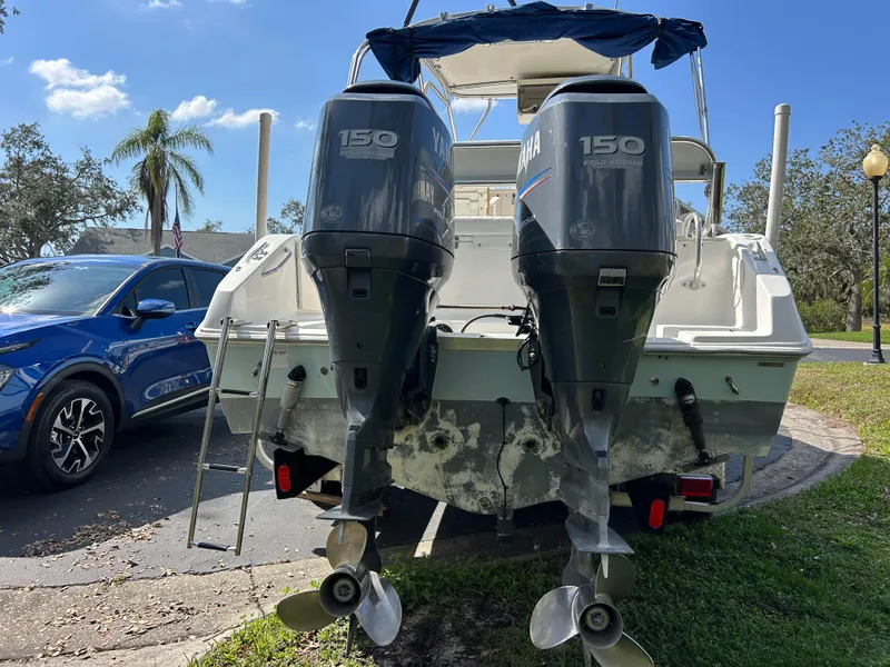 Slide: The Image of 2004 Cobia 250 Walk-Around boat with dual Yamaha 150 engines, parked outdoors. - 9